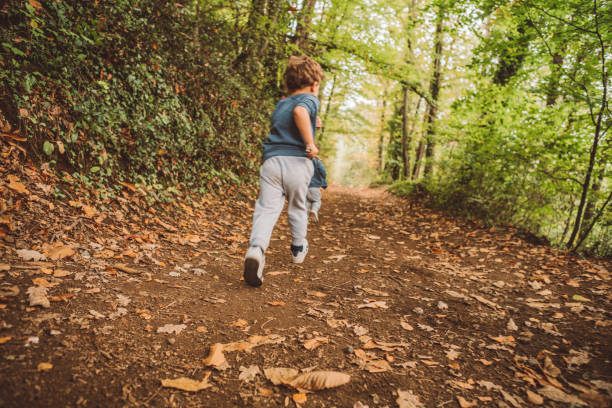 istock Brothers running in the forest 1058733098
