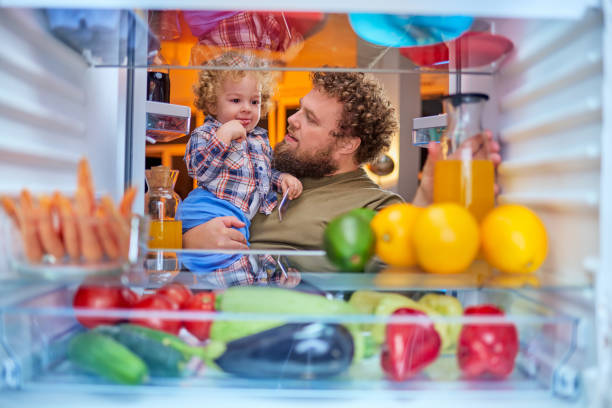 istock Father and son taking food from fridge. 1058733430
