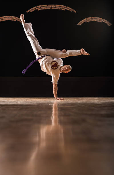 istock Capoeira athlete doing a handstand on a floor and looking at camera. 1058735456