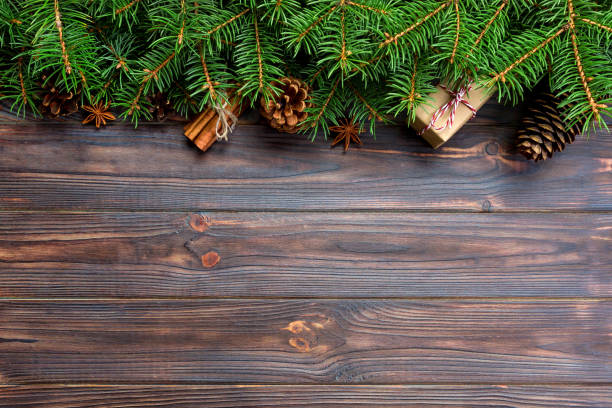 istock gift boxwith cinnamon sticks, anise stars, pine cones and pine branches on wooden table. Top view. Christmas gifts in woodan style 1058738076