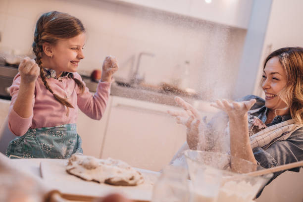 istock Carefree mother and daughter having fun with flour while making a cake. 1058740914