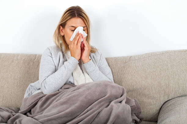 istock Sick woman blowing her nose 1058741202