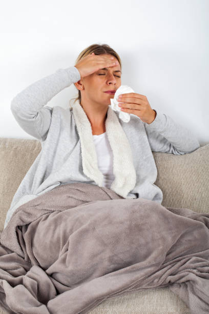 istock Sick woman blowing her nose 1058741226