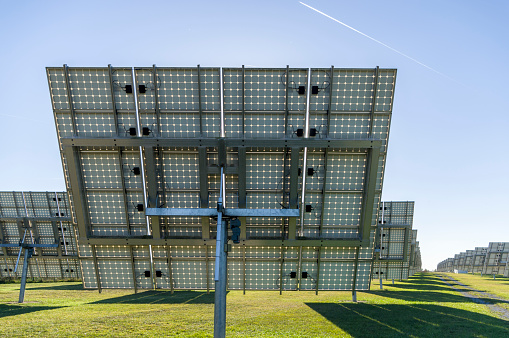 Solar system, overview Solar power plant with trackable elements in sunshine Rear view with module in close-up view