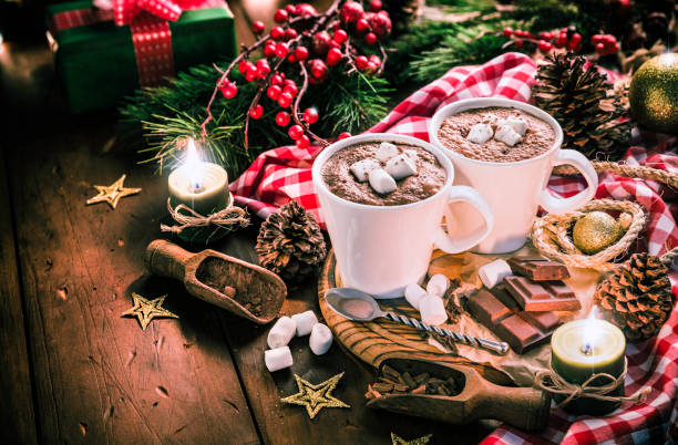 istock Homemade hot chocolate mugs with marshmallows on rustic wooden table with candlelight. Christmas themes. 1058746494