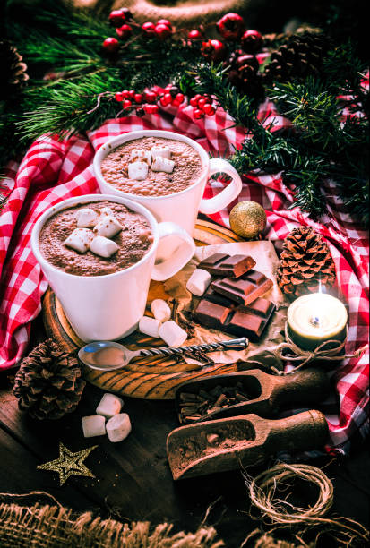 istock Homemade hot chocolate mugs with marshmallows on rustic wooden table with candlelight. Christmas themes. 1058746610