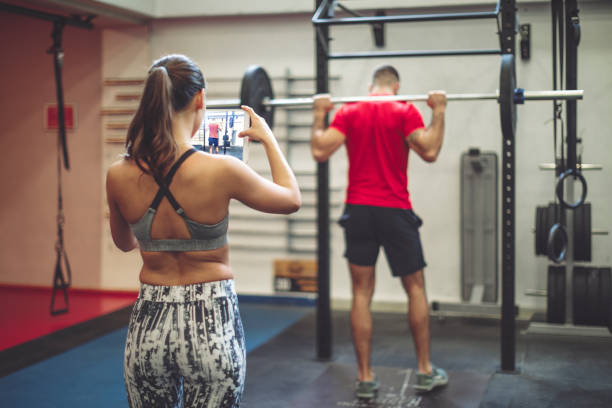la giovane coppia sta facendo esercizi di cross training insieme - weight training body building men human muscle foto e immagini stock