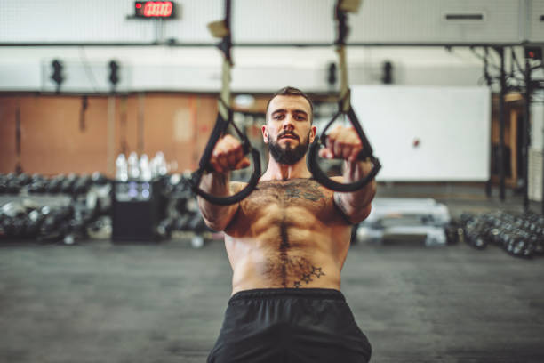 Strong man is doing cross training exercise Strong man is doing cross training exercise suspension training stock pictures, royalty-free photos & images