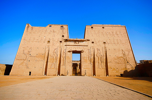 The Temple of Edfu is an Egyptian temple located on the west bank of the Nile in Edfu, Upper Egypt. The city was known in the Hellenistic period as Koinē Greek: Ἀπόλλωνος πόλις and Latin Apollonopolis Magna, after the chief god Horus, who was identified as Apollo under the interpretatio graeca. It is one of the best preserved shrines in Egypt.
