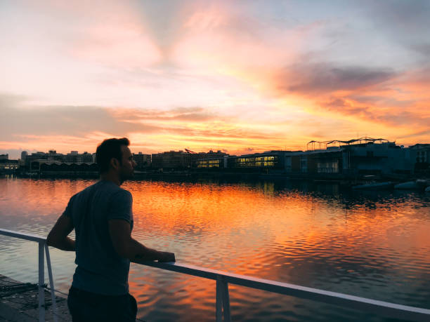 istock Man enjoying the sunset in a harbor 1058751164