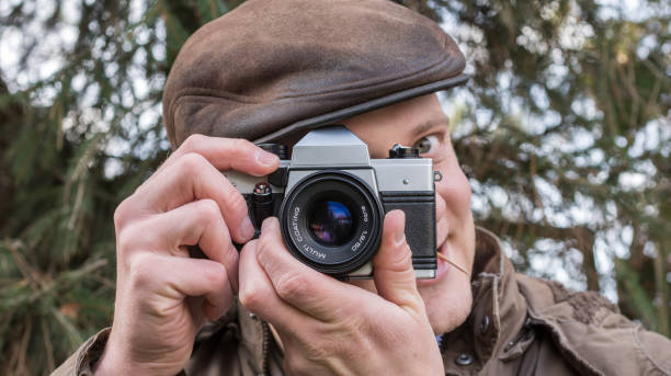 istock Man photographed with old analog camera with a smile on the face 1058751424