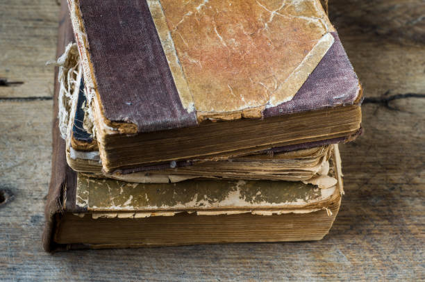 istock Old tattered book on wooden background 1058751980