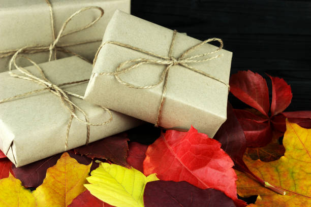 istock three gift boxes in the fall leaves are colored,  on a dark background 1058752544