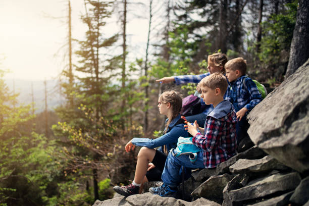 istock Mother and kids hikers resting on trail. 1058754796