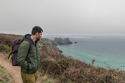 Man out walking along the Cornish coast at Penn Vounder Beach, Porthcurno on an Autumn day.
