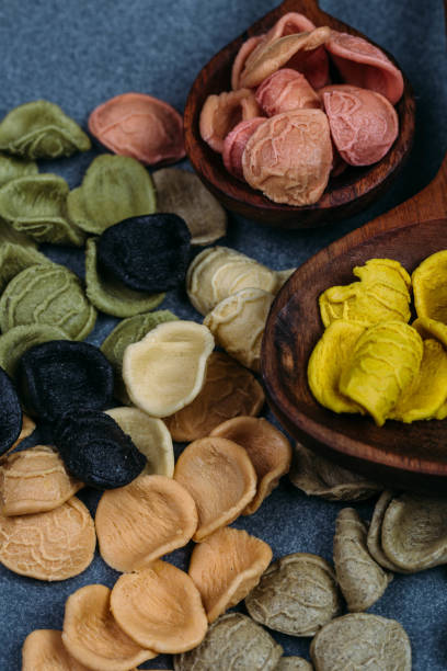 istock Traditional Italian Rainbow pasta. Colored raw pasta on a stone background 1058760056