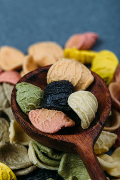 istock Traditional Italian Rainbow pasta. Colored raw pasta on a stone background 1058761252
