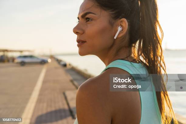 Photo libre de droit de Femme Fitness Fatigués Transpiration Prend Une Pause En Écoutant De La Musique Sur Le Téléphone Après Une Formation Difficile banque d'images et plus d'images libres de droit de Casque audio