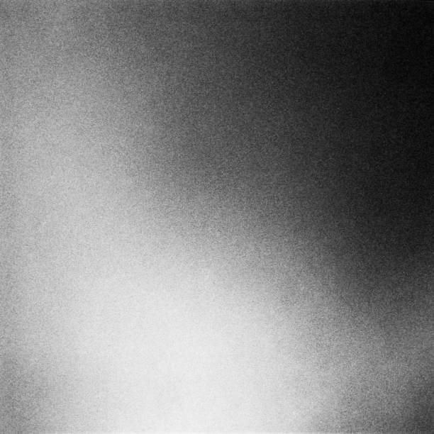 istock Black and white textured background with light leaks and grain. 1058774772