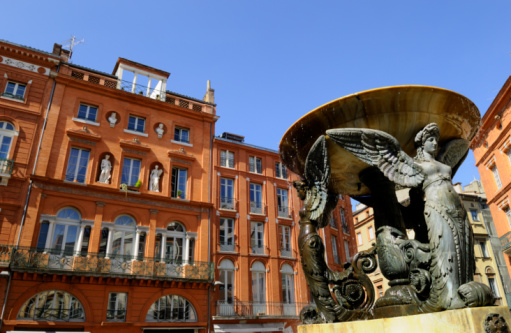 view of French brick buildings and fountain in Toulouse