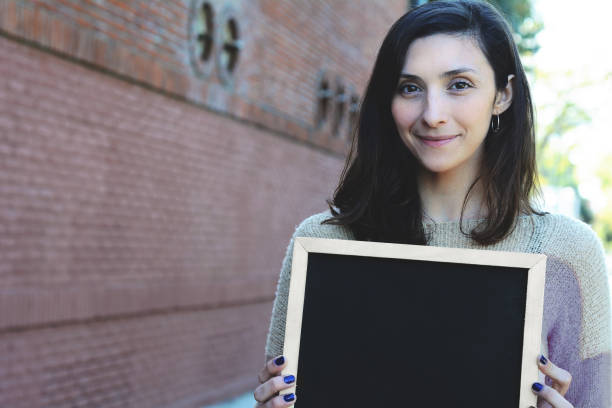 istock Woman holding chalkboard. 1058781508