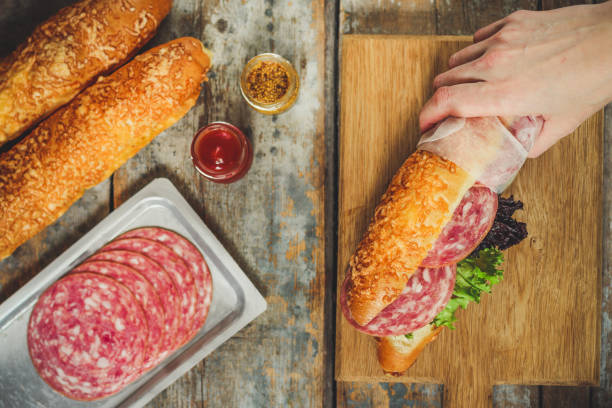 sandwich with bread rolls, lettuce, sausage ham on wooden background. Picnic food. top view