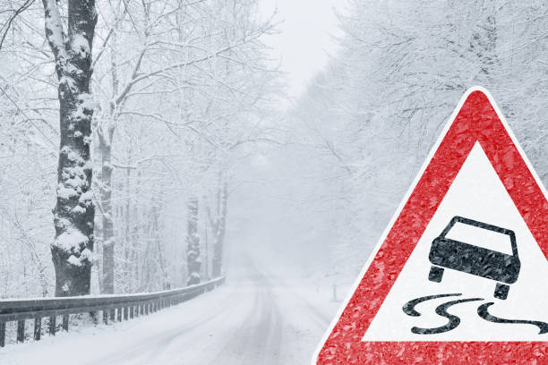 Winter Driving - Snowy Road with Warning Sign stock photo