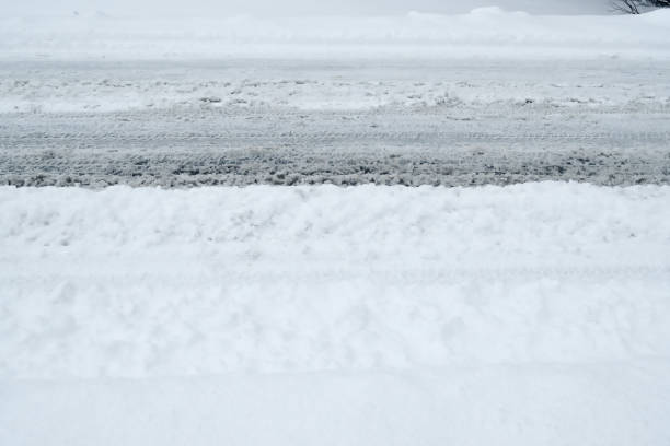istock Winter Driving Background - snowy road with tire tracks 1058785688