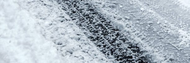 istock Winter Driving Background - snowy road with tire tracks 1058785792
