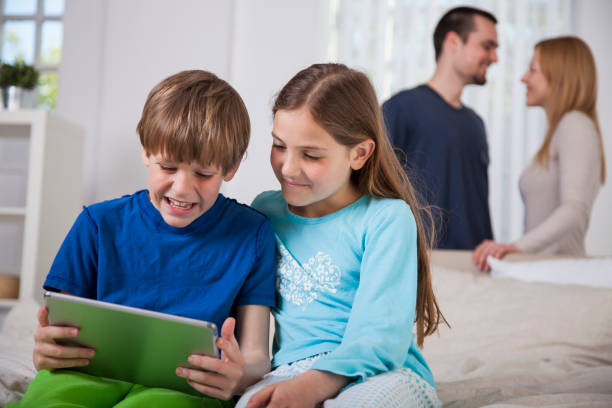 istock Children having fun with digital tablet with loving parents in the back 1058791224