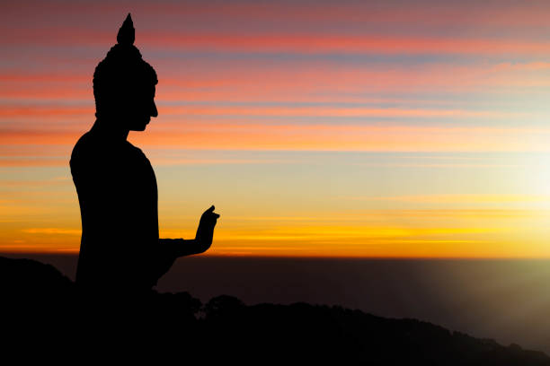 istock Silhouette of Buddha statue on sunrise background 1058793760