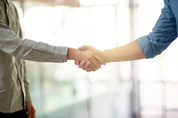 We're going to achieve great things together! Cropped shot of two unrecognizable businessmen shaking hands in the office casual handshake stock pictures, royalty-free photos & images