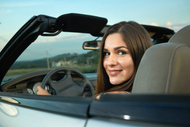 istock Charming model looking back at camera, smiling and driving cabriolet. 1058794782