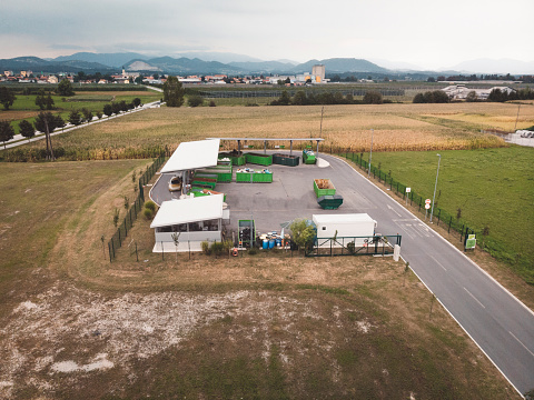 Aerial photo of a recycling centre. There are many recycling containers lined up under the rooftop.