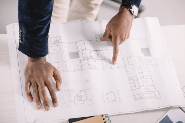 istock cropped view of african american architect working with blueprint 1058803664