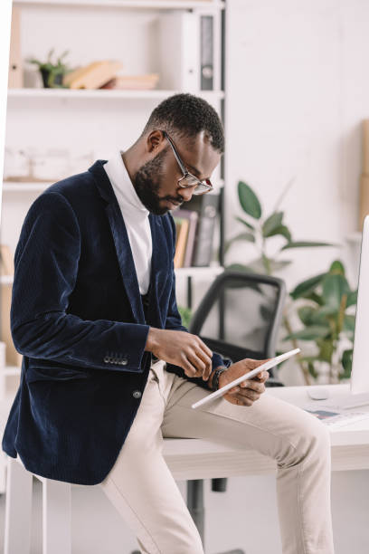 istock bearded african american businessman using digital tablet in office 1058803702