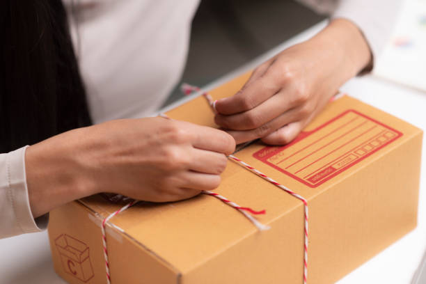 istock Closeup of a worker hands packing a box 1058805282