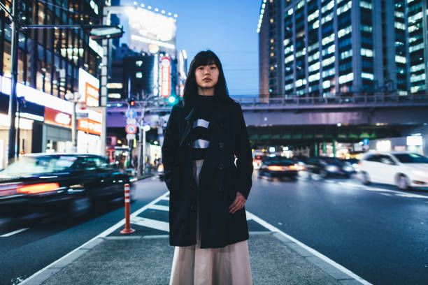 femme debout dans la rue pendant la nuit à tokyo - japan tokyo prefecture city women photos et images de collection