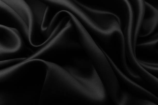istock Elegant black soft silk with waves, texture background 1058805744