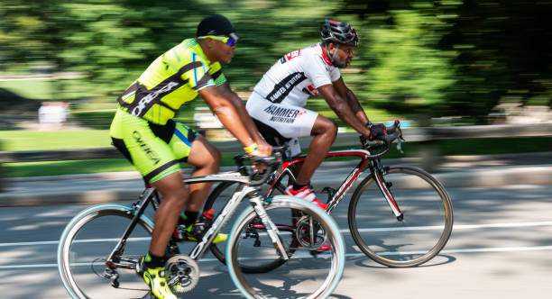 Two African American males on racing bikes in central park NYC stock photo