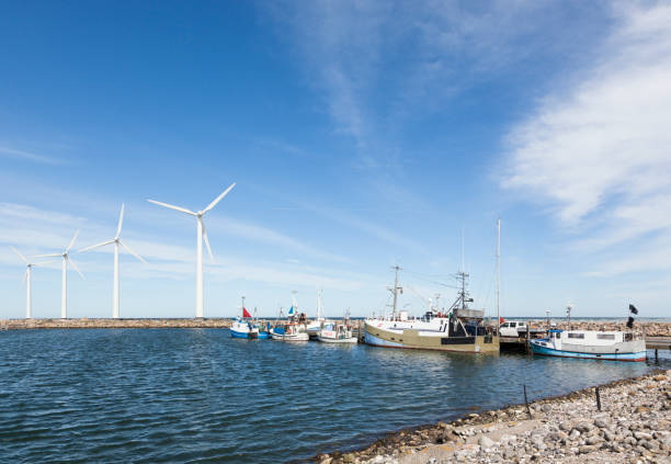 Bonnerup Strand, Denmark - May 4, 2017: The small fishery harbor at Bonnerup on the Baltic Sea coast with wind turbines on the pier