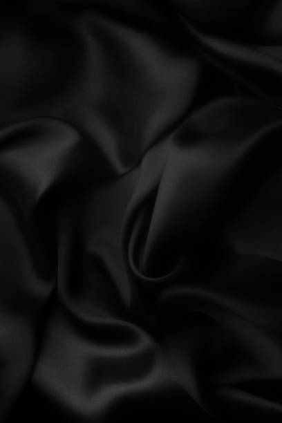 istock Elegant black soft silk with waves, texture background 1058812248