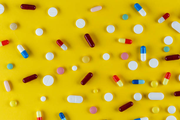 istock different pills and capsules scattered on a yellow background 1058812542