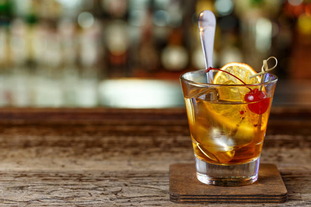 Stylish cocktail on the bar. Cocktail with a garnish of orange, cherry. Cocktail with bourbon