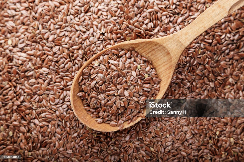 arka plan olarak dağılmış ve içine bir kaşık dökülür keten tohumu - Royalty-free Kahverengi Stok görsel arka plan olarak dağılmış ve içine bir kaşık dökülür keten tohumu - Royalty-free Kahverengi Stok görsel