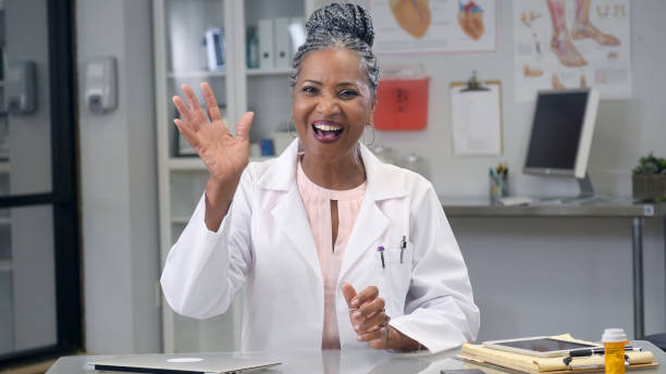 Female doctor waves at camera during web conference