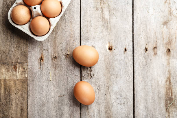 istock chicken eggs in a tray on a wooden background. view from above 1058815464