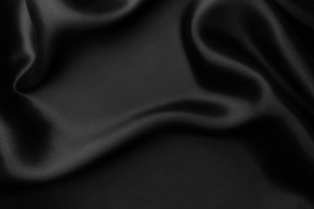 istock Elegant black soft silk with waves, texture background 1058818050