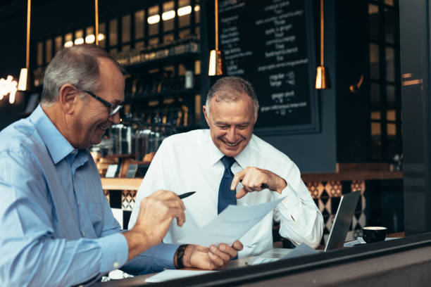 istock Business partners discussing reports at cafe 1058823334