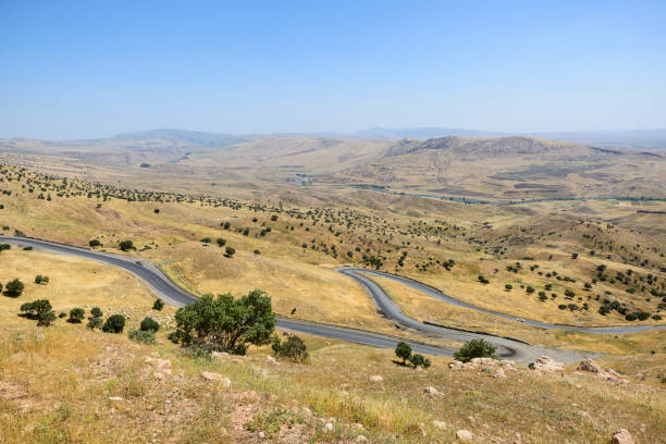 Car on winding road in Iraqi Kurdistan A solitary car drives along a road snaking through the mountains landscape of northern Iraq between the cities of Sulaymaniyah and Koya. kurdistan stock pictures, royalty-free photos & images